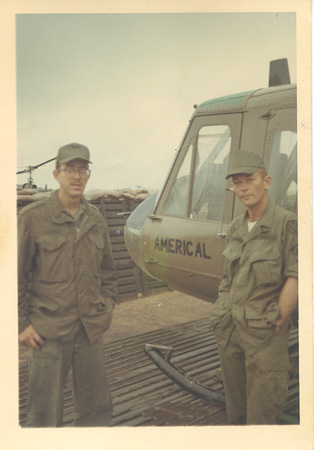 John Hastings and Dwane Connell standing beside one our Huey's repainted with the AMERICAL division name on the door.