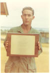 (030) Charles Foster hold the Memorial Plague honoring ROBERT D. ANDERSON, killed in action on September 29, 1967.  The Mess Hall at Ky Ha was renameed in his honor.